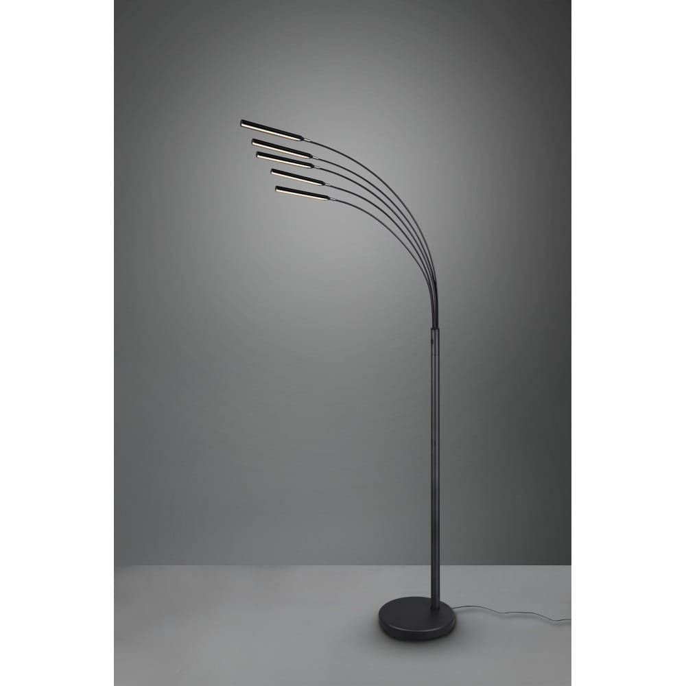 Czarna lampa podłogowa Reed z pięcioma punktami świetlnymi, o łukowatej konstrukcji. Stojąca na okrągłej podstawie, z elastycznymi ramionami, skierowanymi w różne strony. Tło w odcieniach szarości, podkreślające nowoczesny design.