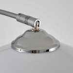 Lampa podłogowa Brasilia z chromowanym wykończeniem. Widoczna metalowa podstawa z zaokrąglonym kształtem oraz chromowanym elementem łączącym z przewodem. Stylowy detal, który łączy funkcjonalność z elegancją.
