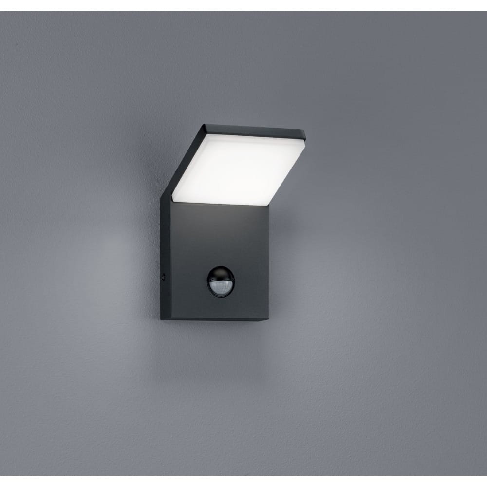 Kinkiet elewacyjny Pearl LED 1-punktowy w kolorze antracytowym z zamontowanym czujnikiem ruchu. Oświetlenie w kształcie prostokątnej płyty, lekko pochylonej, zamontowane na ścianie. Tło w odcieniu szarości.