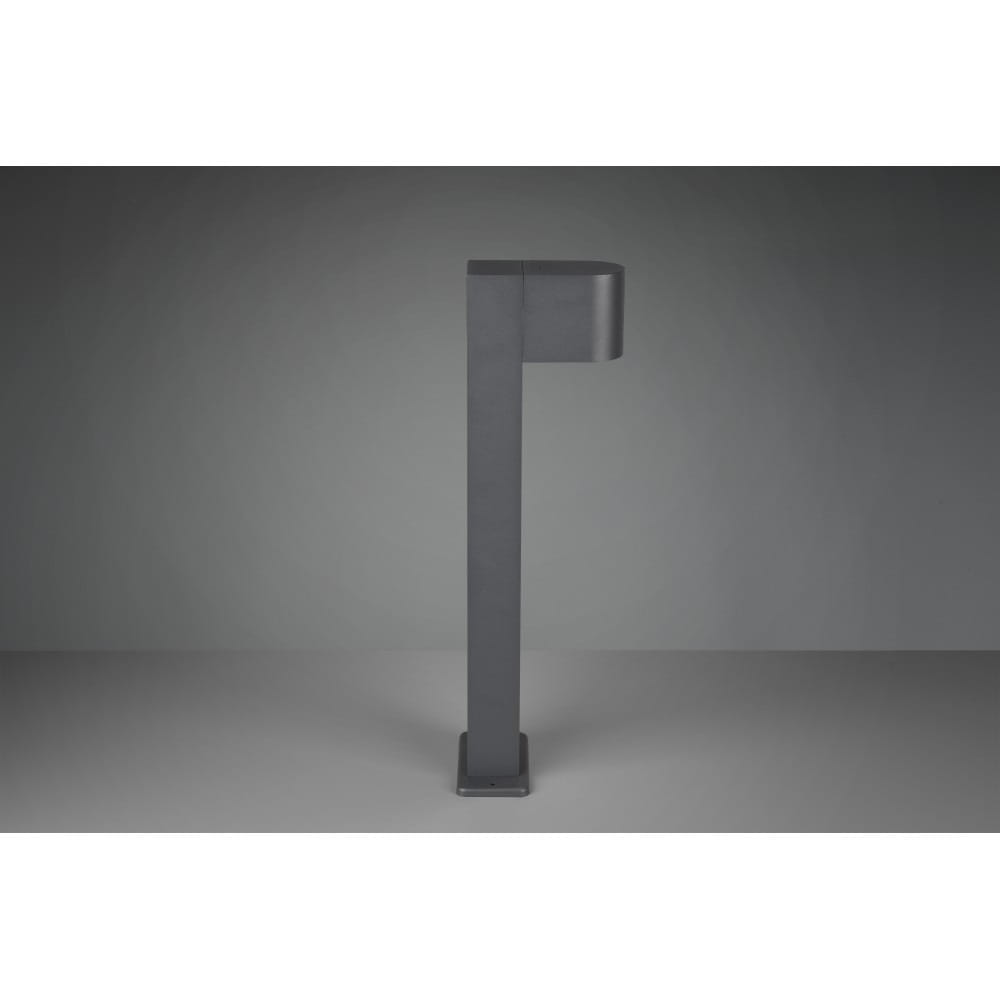 Lampa stojąca ogrodowa Roya H50 w kolorze antracytowym, o prostokątnym kształcie z zaokrąglonym kloszem. Ustawiona pionowo na kwadratowej podstawie, prezentuje nowoczesny design. Tło szare, minimalistyczne, podkreśla elegancję lampy.