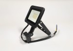 Naświetlacz LED halogenowy 20W z czujnikiem ruchu, kolor czarny. Kwadratowa głowica z wieloma diodami LED, umieszczona na regulowanym ramieniu. Widoczny kabel podłączający oraz czujnik ruchu w dolnej części. Wodoodporność IP65.