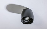 Czarna lampa sufitowa kierunkowa Rotondo AZ4208, o opływowym kształcie, z widoczną żarówką w centralnej części. Ujęcie z góry, na białym tle, ukazujące detale konstrukcji i fakturę matowego wykończenia.