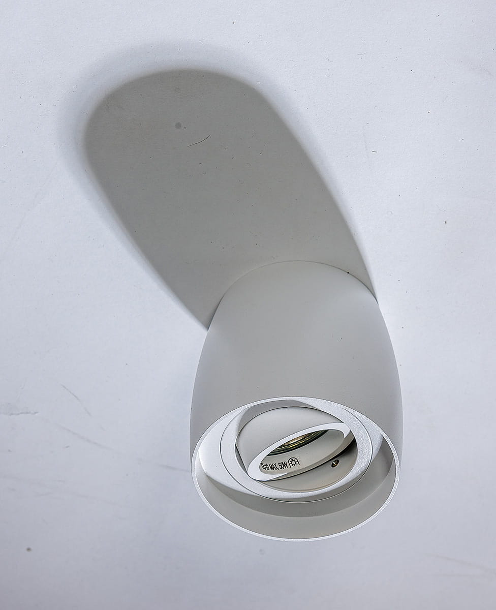 Biała lampa sufitowa kierunkowa Rotondo AZ4207, z okrągłym kloszem w kształcie stożka, zamontowana na suficie. Widoczna żarówka w środku, prosta forma bez zdobień. Tło w jasnym kolorze, co podkreśla minimalistyczny design lampy.