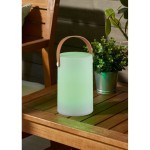Biała lampa stołowa Aruba LED w kształcie cylindra z brązowym uchwytem, umieszczona na drewnianym stole. Lampa emituje delikatne zielone światło, obok znajduje się doniczka z rośliną.