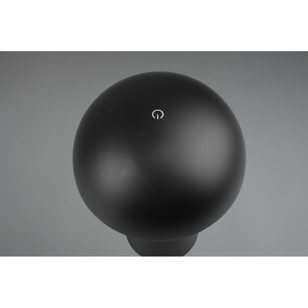 Czarna lampa stołowa LED Lennon o okrągłym kształcie, widoczna z góry. Posiada niewielki przycisk włączania w kolorze białym na górze. Lampa wykonana z matowego materiału, idealna do użytku w ogrodzie.