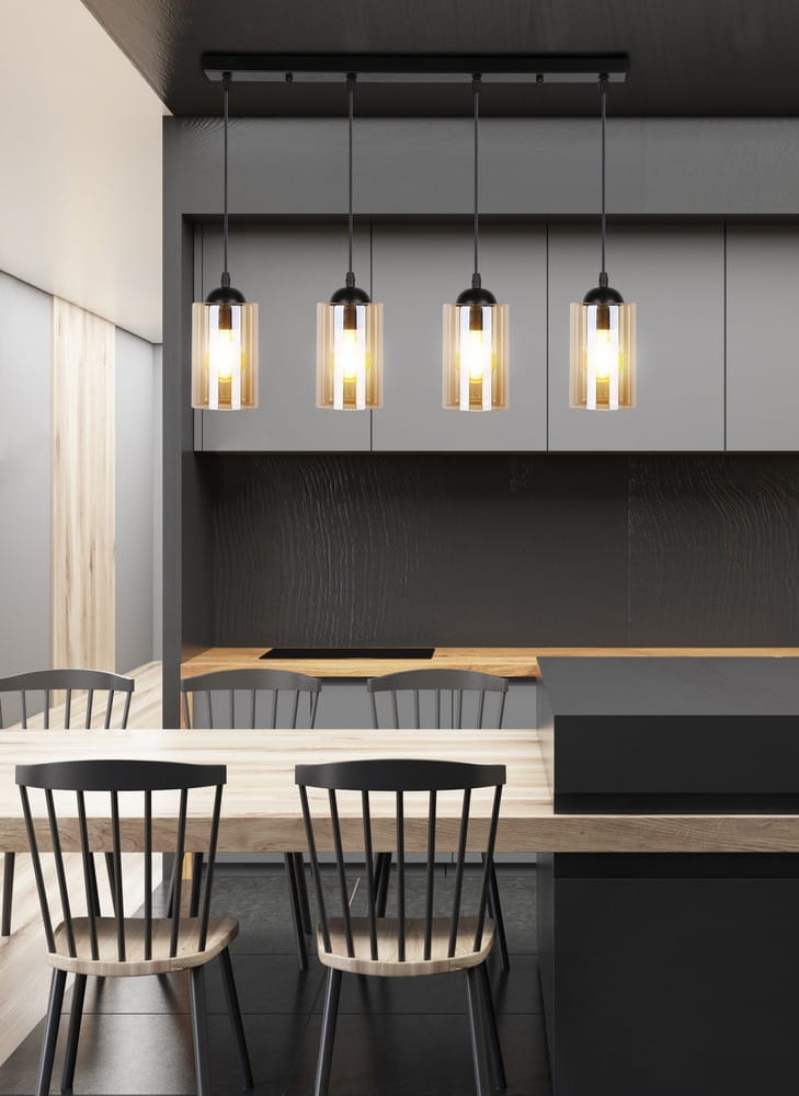 Czarna lampa wisząca Bistro 4-punktowa, zawieszona na prostokątnej podstawie, z przezroczystymi kloszami. Lampa o nowoczesnym designie, umieszczona nad drewnianym stołem w minimalistycznej kuchni.