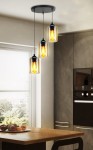 Lampa wisząca Bistro 3-punktowa w kolorze czarnym, z trzema szklanymi kloszami w kształcie cylindrów, emitującymi ciepłe światło. Zawieszona na cienkich linkach, montowana na okrągłej podstawie sufitowej, w nowoczesnej kuchni z drewnianym stołem.