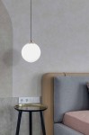 Lampa wisząca Isla D30 w kolorze czarnym z elementami patyny, zawieszona na cienkim kablu. Okrągły, biały klosz z matowego szkła w centrum, umieszczony nad niskim stolikiem z metalową, złotą powierzchnią, w nowoczesnym wnętrzu.