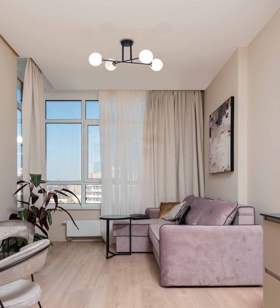 Lampa sufitowa Isla 4-punktowa w kolorze czarnym z elementami patyny, z widocznymi białymi kloszami, zamontowana na suficie w nowoczesnym wnętrzu. Lampa ma minimalistyczny design, idealna do aranżacji salonu.