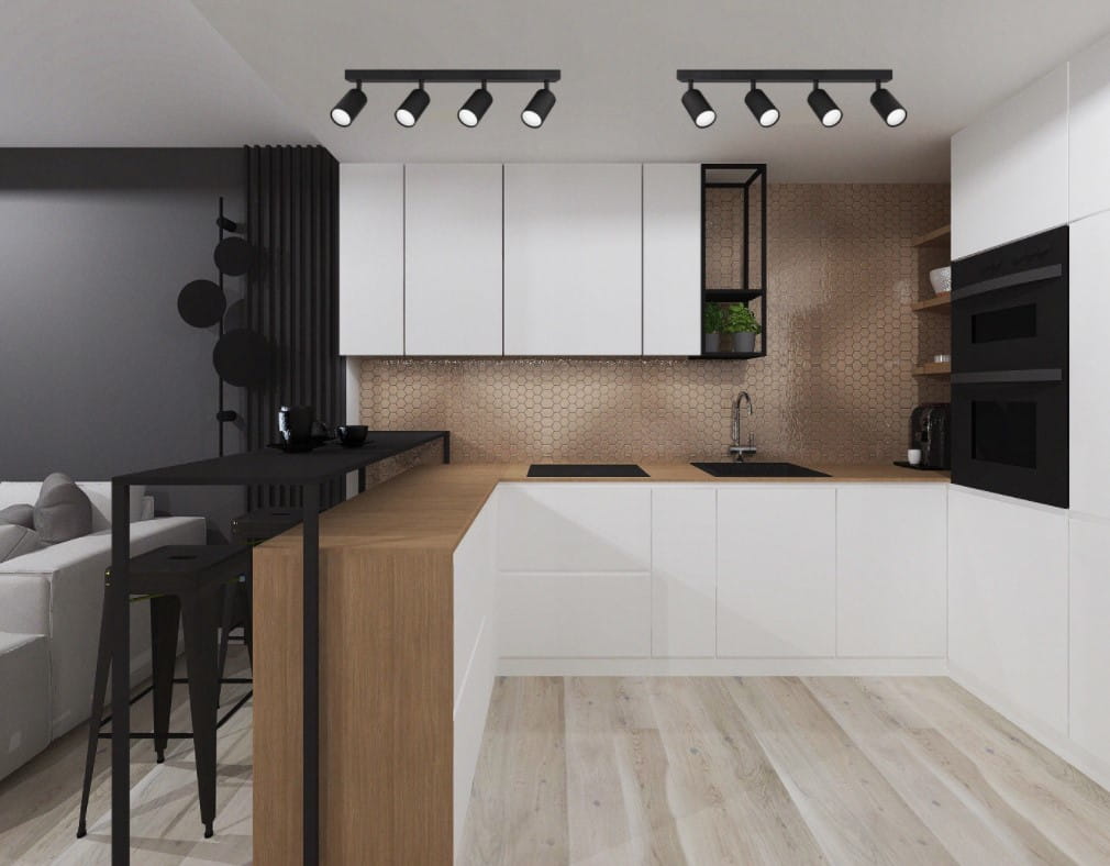 Czarna lampa sufitowa (spot) 4-punktowa, umieszczona w kuchni, z czterema regulowanymi reflektorami. Lampa zawieszona nad drewnianym blatem, w nowoczesnym wnętrzu z białymi meblami i miedzianą ścianą.
