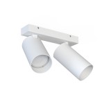 Biała lampa sufitowa (spot) 2-punktowa z metalowym ramieniem, z dwiema cylindrycznymi oprawami, zawieszona na prostej podstawie. Zbliżenie na detale kloszy, które są gładkie i matowe, bez widocznych napisów. Tło białe, proste.