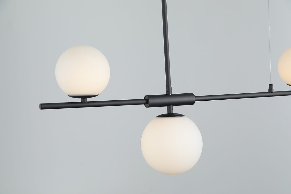Czarna lampa wisząca Santander 4-punktowa z matowymi, okrągłymi kloszami. Ujęcie z boku, pokazujące cztery kuliste źródła światła zawieszone na poziomej rurze. Prosty, nowoczesny design, idealny do minimalistycznych wnętrz.