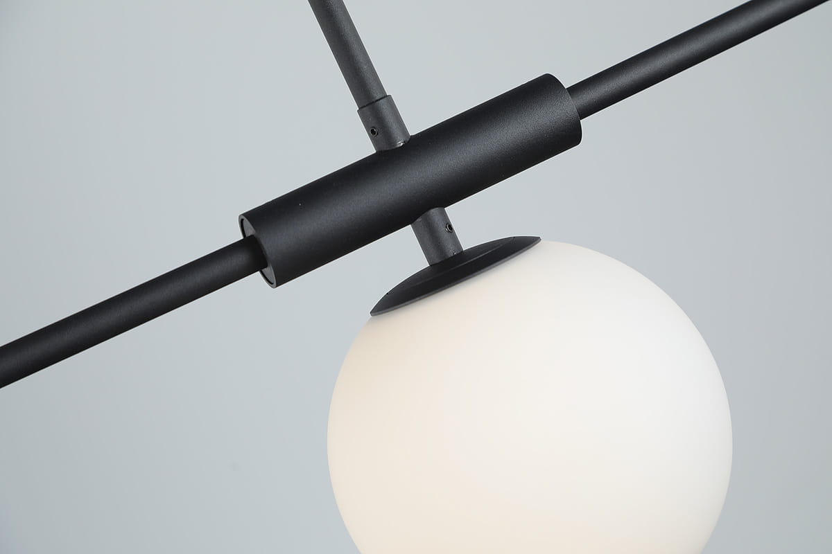 Czarna lampa wisząca Santander 4-punktowa z matowym, białym kloszem w kształcie kuli. Ujęcie z góry, ukazujące elementy mocujące oraz połączenia metalowych rur. Prosta, nowoczesna konstrukcja, idealna do aranżacji wnętrz.