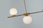 Złota lampa wisząca Santander 4-punktowa z białymi, matowymi kulami. Ujęcie z boku, pokazujące dwa źródła światła na poziomej rurze. Prosta, nowoczesna konstrukcja, zawieszona na cienkich linkach, na stonowanym tle.