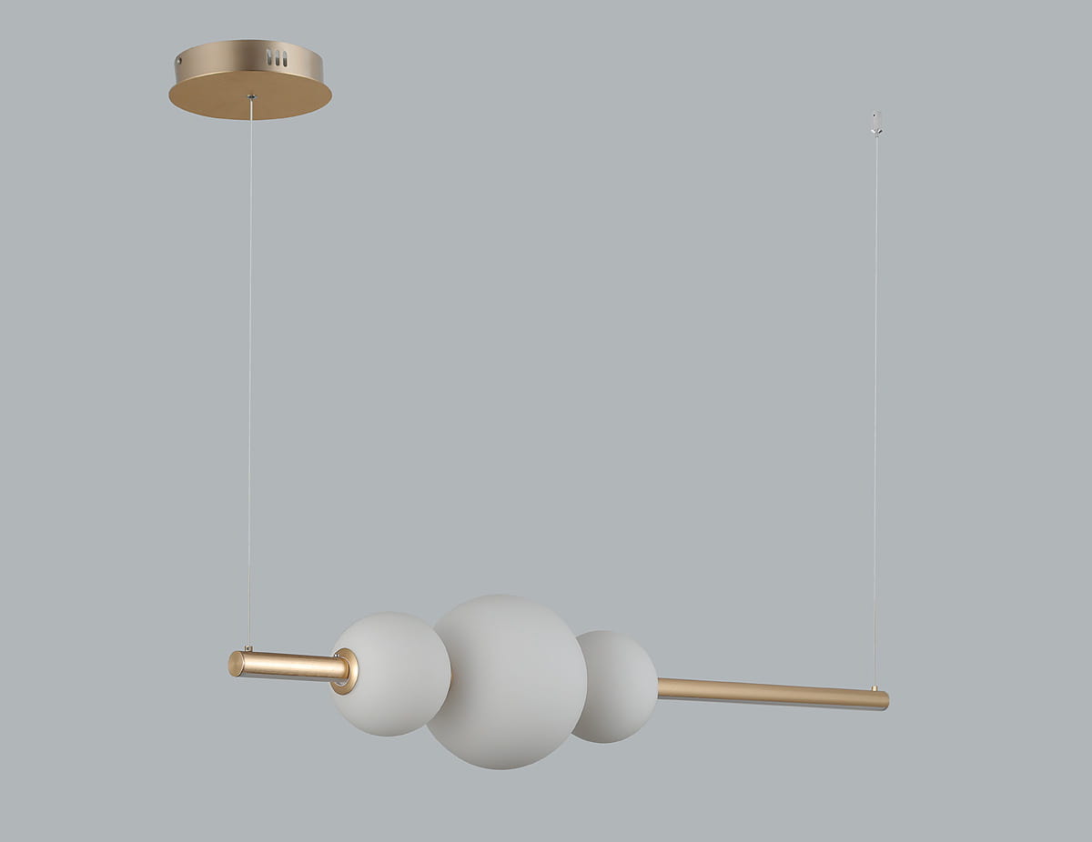 Złota lampa wisząca Sandra LED z jednym punktem świetlnym. Okrągłe, matowe klosze w białym kolorze połączone z metalowym, złotym ramieniem. Produkt zawieszony na cienkim przewodzie, montowany do sufitu. Tło w jednolitym szarym kolorze.