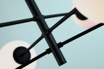 Lampa wisząca Oviedo 6-punktowa w kolorze czarnym, z metalowymi ramionami i okrągłymi kloszami. Ujęcie z dołu, ukazujące detale konstrukcji oraz mocowania. Tło w jasnym kolorze, podkreślające nowoczesny design.