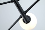 Czarna lampa wisząca Oviedo z sześcioma punktami świetlnymi, z metalową konstrukcją. Ujęcie z góry, ukazujące detale mocowania i okrągłe klosze emitujące miękkie światło. Prosta, nowoczesna forma, idealna do wnętrz.
