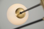 Lampa wisząca Oviedo 8-punktowa w kolorze czarnym i złotym. Ujęcie z bliska na element mocujący z metalową, złotą podstawą oraz matową, białą kulą. Produkt ma nowoczesny design, z prostymi liniami i eleganckim wykończeniem.