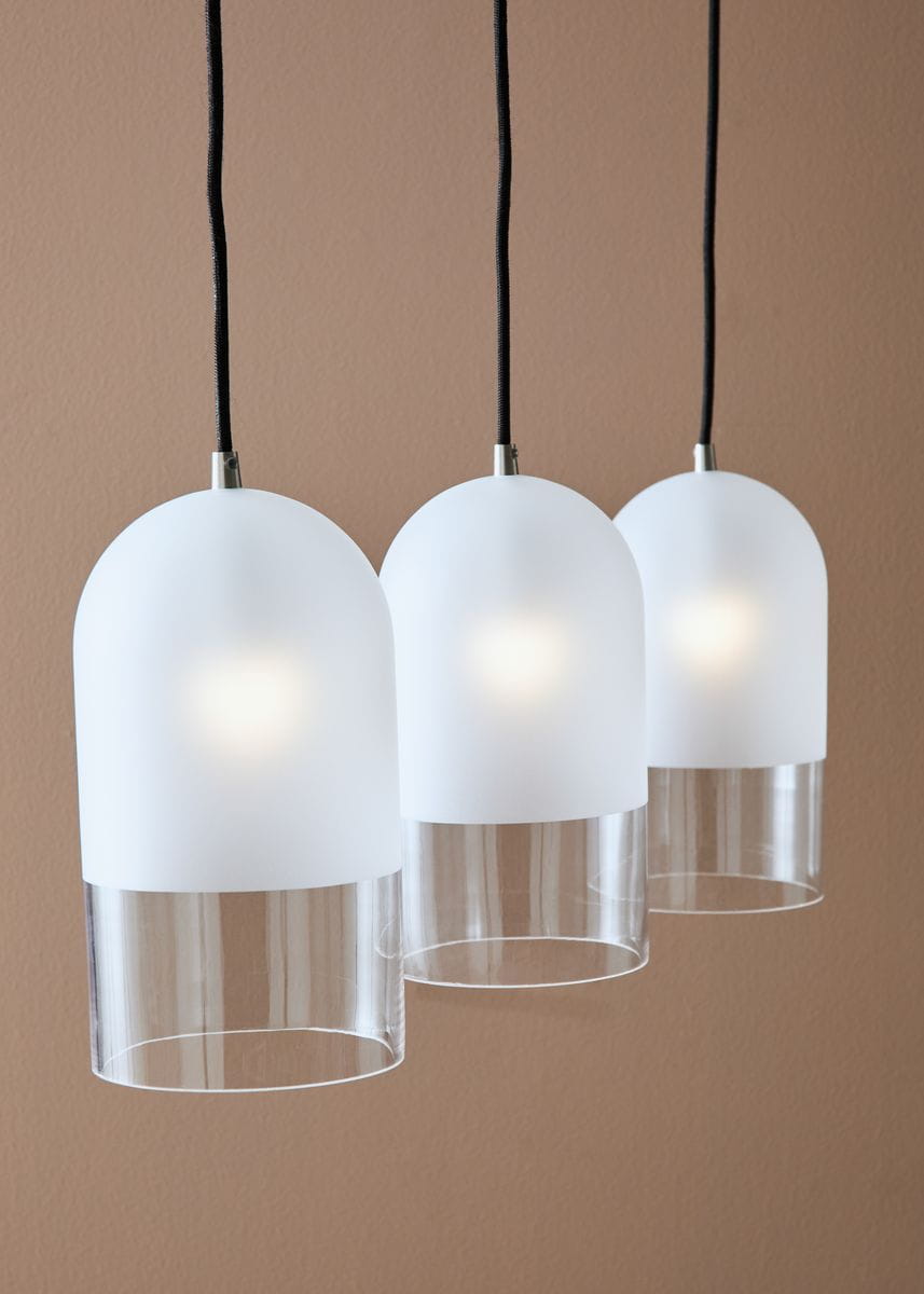 Lampa wisząca Cope, 3-punktowa, z matowymi kloszami w kształcie półkul i przezroczystymi dolnymi elementami. Zawieszona na czarnych przewodach, w minimalistycznym stylu, idealna do nowoczesnych wnętrz.