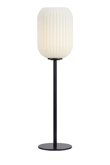 Cava lampa stołowa 1-punktowa w czarnej podstawie z białym, teksturowanym kloszem w kształcie walca. Lampa stoi na okrągłej podstawie, o delikatnej, nowoczesnej formie. Widoczna struktura klosza dodaje elegancji.