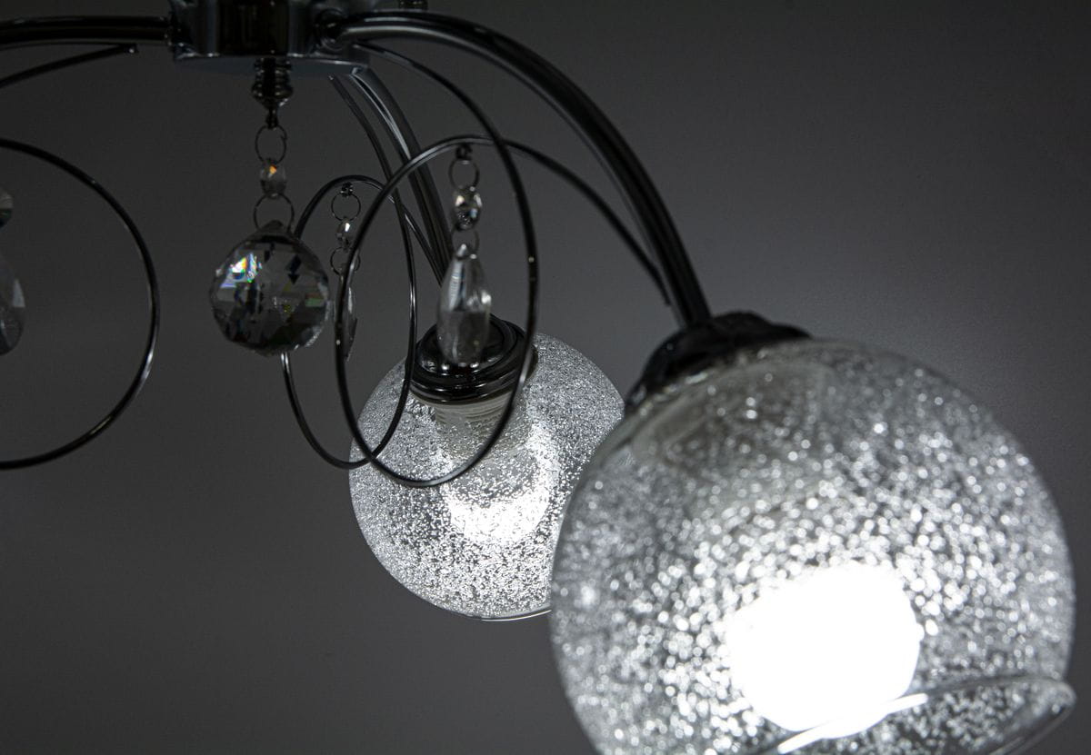 Lampa sufitowa Carmen 3-punktowa w kolorze chromu. Posiada okrągłe klosze z teksturowanego szkła, ozdobione kryształkami. Ujęcie z góry, ukazujące dwa klosze i dekoracyjne elementy. Idealna do nowoczesnych wnętrz.