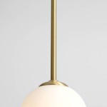 Lampa wisząca Bosso D30 w kolorze mosiężnym z okrągłym, matowym kloszem. Produkt zawieszony na cienkim, metalowym wysięgniku. Tło jasnoszare, podkreślające elegancki design lampy.