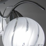 Lampa sufitowa 3-punktowa Sting w kolorze chromu. Szklane klosze o dekoracyjnej, spiralnej fakturze. Ujęcie z góry, skupione na detalach kloszy i metalowych elementów mocujących. Tło proste, szare.