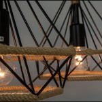 Lampa wisząca Piramida 2-punktowa w kolorze czarnym z naturalnym sznurkiem. Widoczne dwa źródła światła w przezroczystych kloszach, metalowa konstrukcja w formie piramidy z dekoracyjnym sznurkiem. Ujęcie zbliżeniowe na detale.