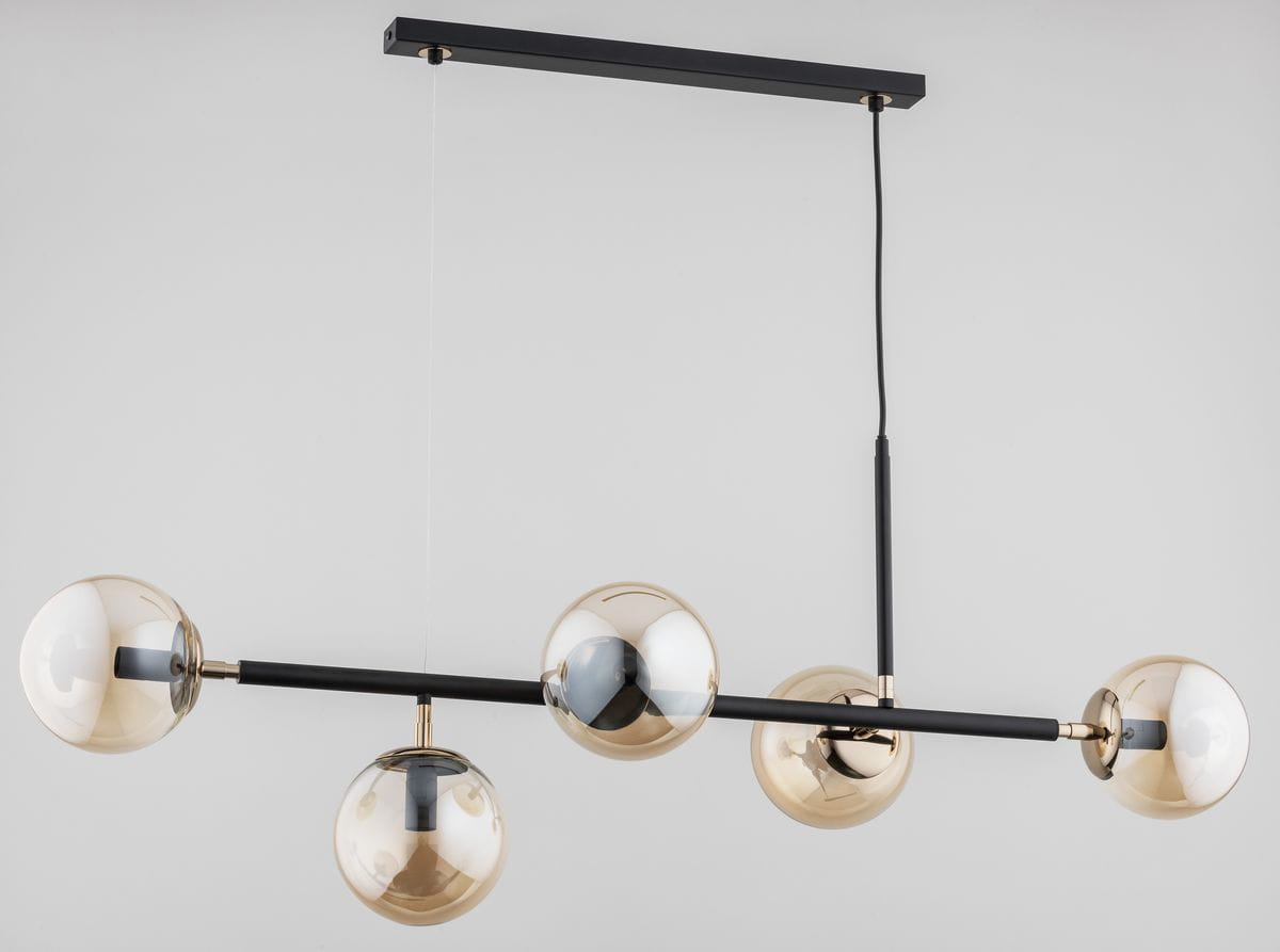 Lampa wisząca Dansa 5-punktowa w kolorze czarnym i złotym, z prostą metalową konstrukcją. Posiada pięć szklanych kloszy w złotym odcieniu, zawieszona na cienkim kabelku. Ujęcie z przodu, ukazujące równomierne rozmieszczenie kloszy.