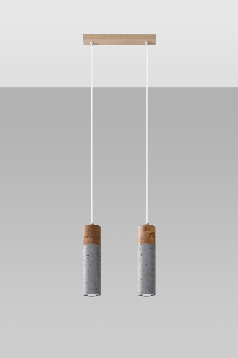 Lampa wisząca Zane 2-punktowa w odcieniu szarym z betonowymi cylindrami i drewnianymi elementami. Zawieszona na dwóch białych przewodach, montowana na prostokątnej drewnianej podstawie. Prosta, nowoczesna forma, idealna do różnych aranżacji wnętrz.