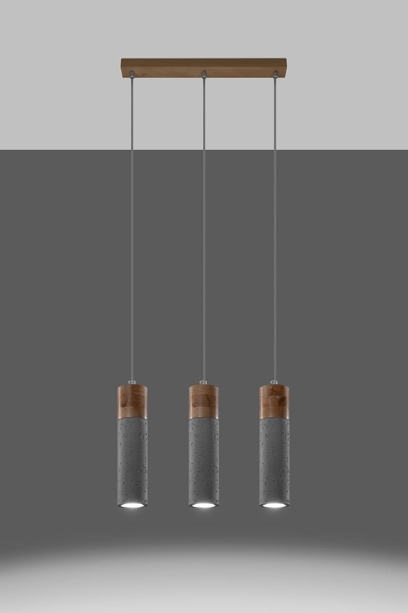 Lampa wisząca Zane 3-punktowa w kolorze szarym z betonowymi kloszami i drewnianymi elementami. Ułożona w trzech wiszących cylindrach, zawieszonych na cienkich linkach, z górnym drewnianym mocowaniem. Idealna do nowoczesnych wnętrz.