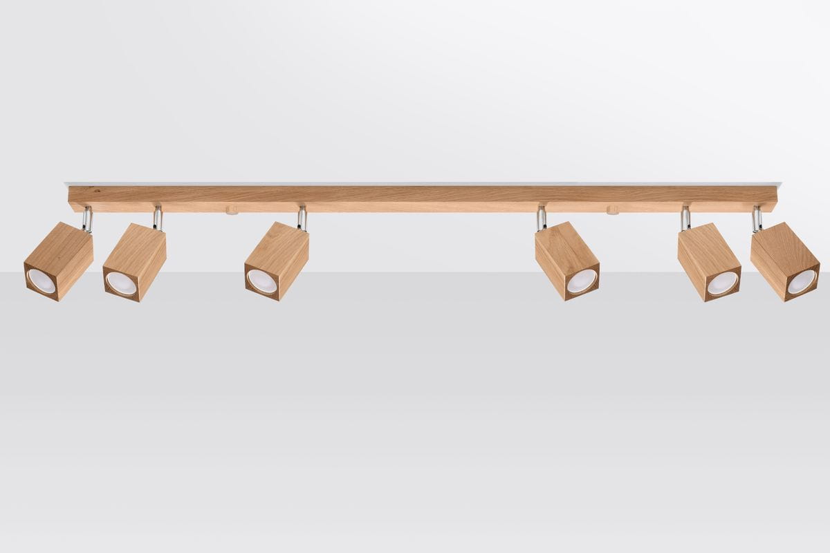 Lampa sufitowa Keke 6-punktowa w formie spotów, z drewnianymi, prostokątnymi oprawami w kolorze jasnego dębu. Ułożona poziomo na metalowej listwie, z możliwością regulacji kąta świecenia. Tło jasnoszare, jednolite.