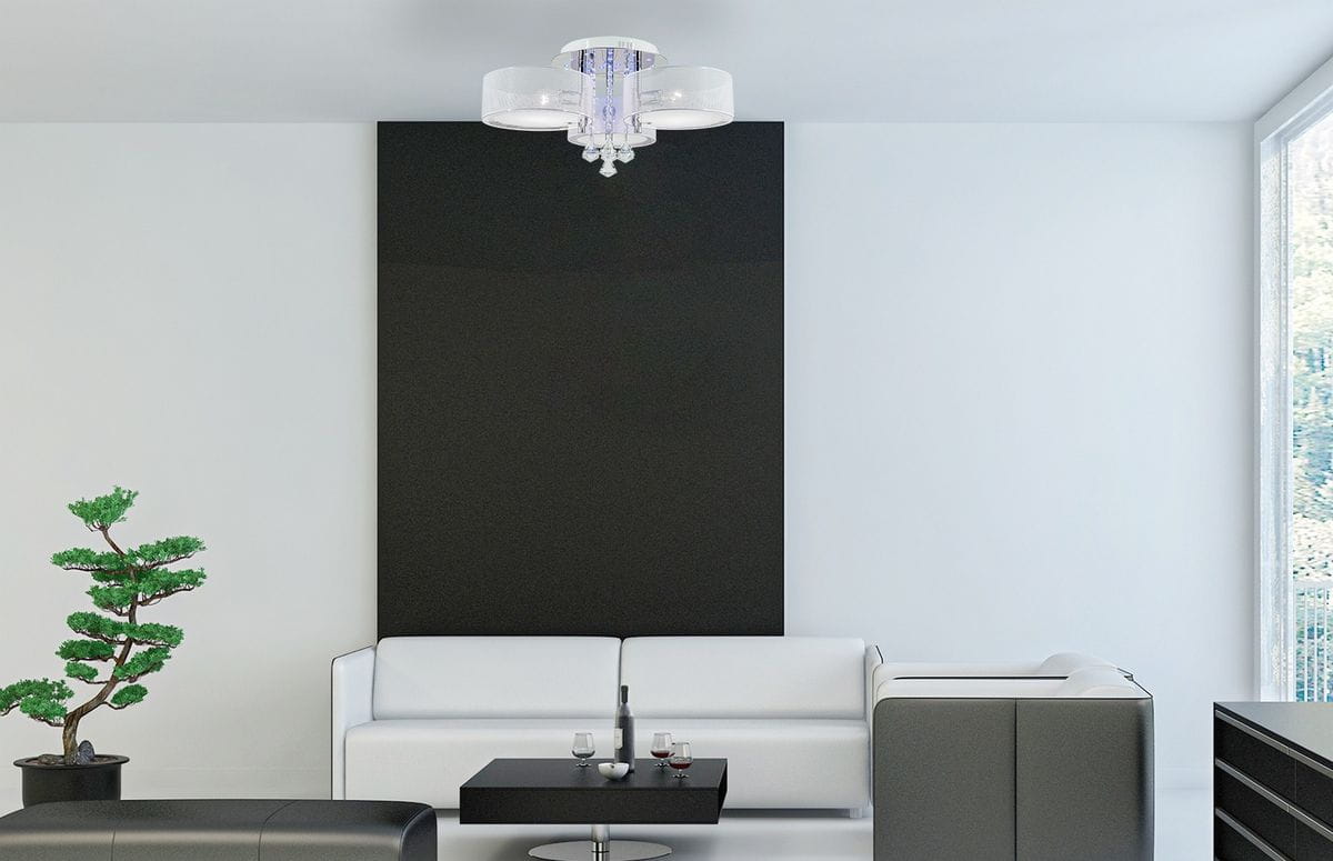 Lampa sufitowa Antila E27 3-punktowa w kolorze chromowanym z białą siatką, zawieszona na suficie, z pilotem. W otoczeniu nowoczesnego wnętrza z białą kanapą, czarnym stolikiem i rośliną. Widoczny detal z przezroczystymi kryształkami.