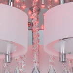 Lampa sufitowa Antila E27, 5-punktowa, z pilotem, w kolorze chromu i bieli. Okrągłe klosze z matowego szkła, zdobione kryształkami, z widocznymi diodami LED. Ujęcie z bliska, ukazujące detale i fakturę materiałów.