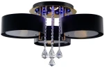Lampa sufitowa Antila E27 w kolorze złotym i czarnym, 3-punktowa, z pilotem. Posiada trzy cylindryczne klosze, ozdobne kryształowe elementy oraz podświetlenie LED. Ujęcie z dołu, produkt zamontowany na suficie.