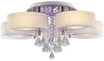 Lampa sufitowa Antila E27 z 5 punktami świetlnymi, w kolorze złotym i białym. Posiada okrągłe klosze z matowego szkła, wiszące kryształowe dekoracje oraz pilot do zdalnego sterowania. Ujęcie z przodu, z detalami kryształów i kloszy.