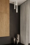 Lagos H60 lampa sufitowa 1-punktowa w kolorze białym, zawieszona z sufitu w trzech równych odstępach. W tle widoczna drewniana ściana oraz szare zasłony, a na podłodze metalowe pojemniki.