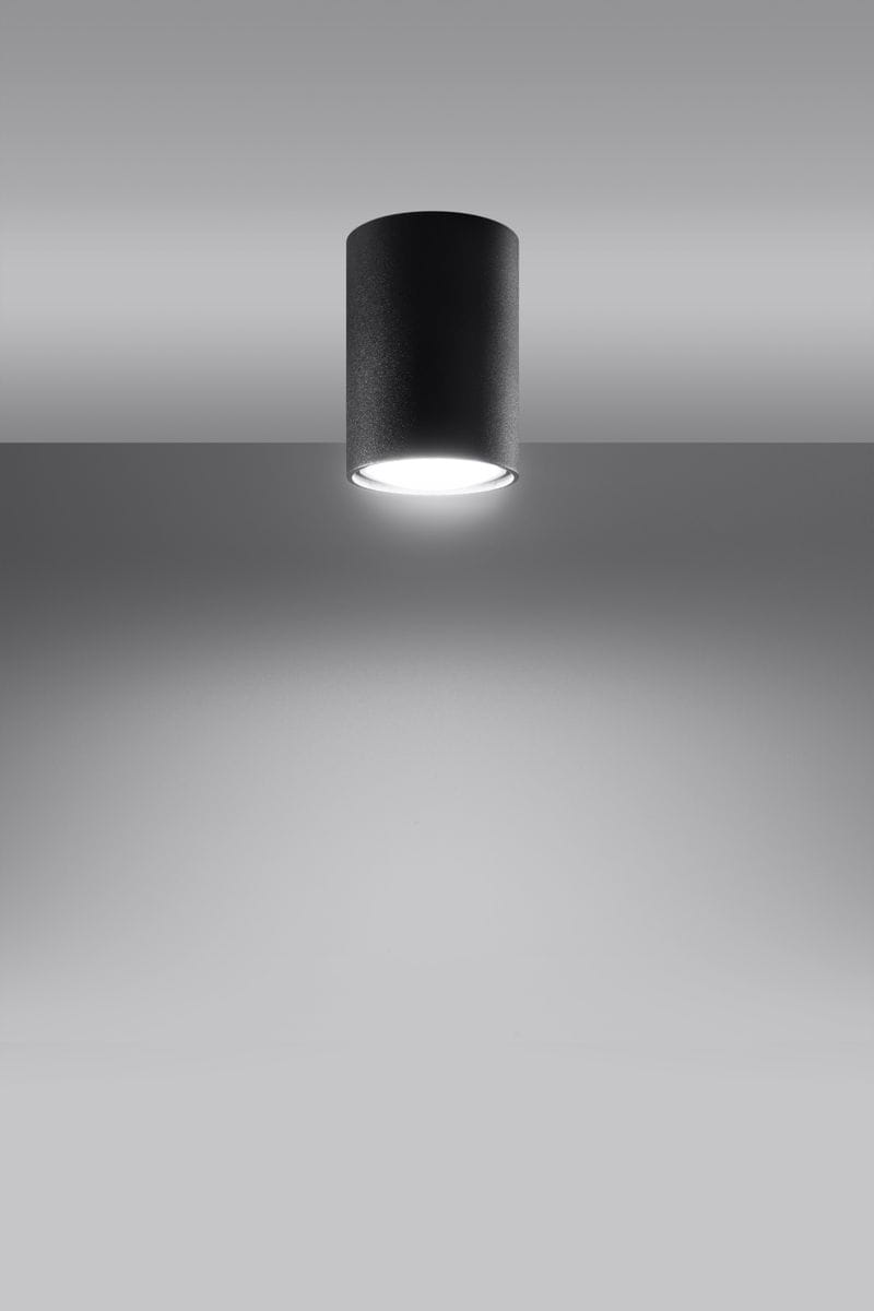 Lagos H10 to czarna lampa sufitowa 1-punktowa w kształcie cylindrycznym, umieszczona na szarym tle. Widoczna jest jasna oprawa świetlna na dole lampy, co podkreśla jej minimalistyczny design. Lampa jest zamontowana na suficie, w pozycji pionowej.