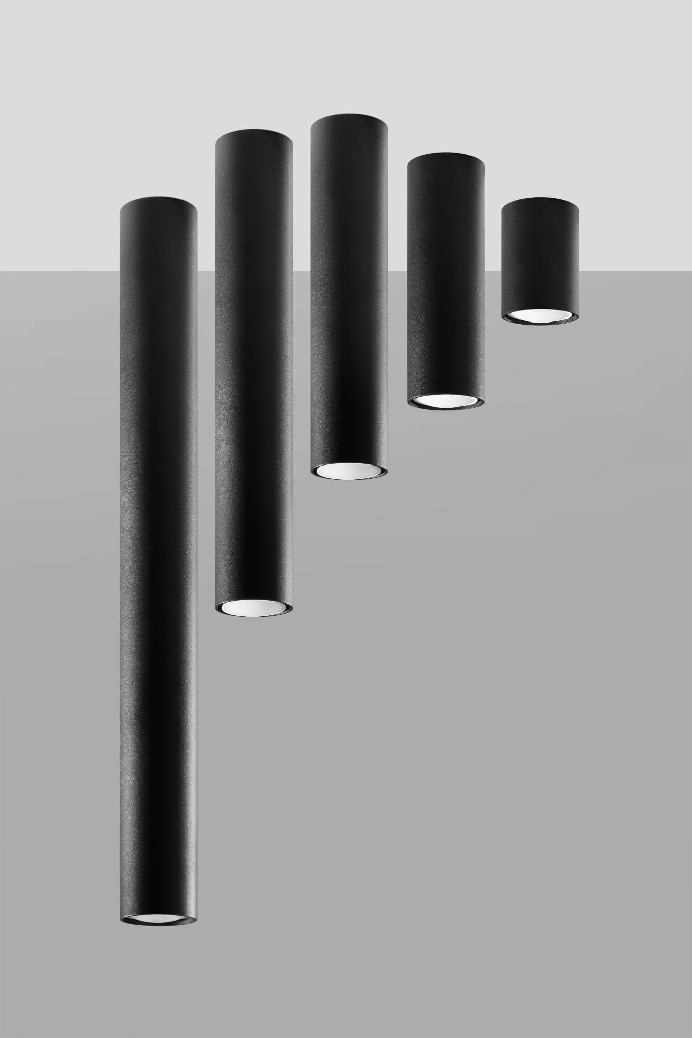 Lagos H10 lampa sufitowa 1-punktowa, czarna, w formie cylindrów o różnej wysokości, zawieszona na szarym tle. Górna część lampy ma matową teksturę, a dolna część jest otwarta, emitując światło. Ujęcie z przodu, pokazujące wszystkie elementy lampy.