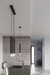 Czarna lampa wisząca Wezyr 1-punktowa, z metalowym kloszem w cylindrycznym kształcie. Ujęcie z boku, zawieszona na cienkim kablu, w nowoczesnej kuchni z szarymi panelami ściennymi i minimalistycznym blatem.