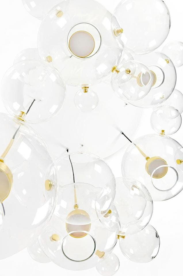 Lampa wisząca Capri Disc LED 5-punktowa z przezroczystymi kloszami w kształcie kul, z elementami w kolorze złotym. Ujęcie z dołu, ukazujące różne rozmiary kul i ich rozmieszczenie. Wnętrze kloszy z białymi źródłami światła.