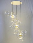 Lampa wisząca Capri Disc LED 3-punktowa w złotym kolorze, z przezroczystymi kloszami w kształcie bąbelków. Lampa zawieszona na cienkich linkach, z centralnym okrągłym mocowaniem sufitowym. Idealna do nowoczesnych wnętrz.
