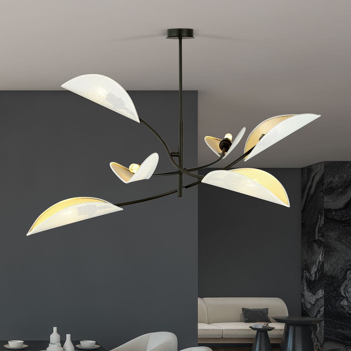 Lampa sufitowa Lotus 6-punktowa w białym i złotym kolorze, z sześcioma asymetrycznymi kloszami w kształcie liści, zawieszona na czarnym stelażu. Klosze mają teksturowaną powierzchnię, emitując ciepłe światło, umieszczona w nowoczesnym wnętrzu.