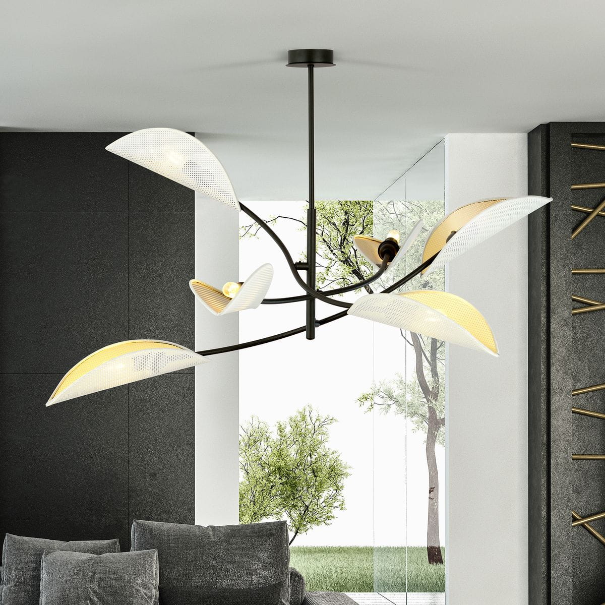 Lampa sufitowa Lotus 6-punktowa w kolorze białym i złotym, z eleganckimi, lekko falistymi kloszami. Ułożona w wiszącej pozycji, prezentuje nowoczesny design. Tło stanowi jasne wnętrze z widokiem na zieleń.