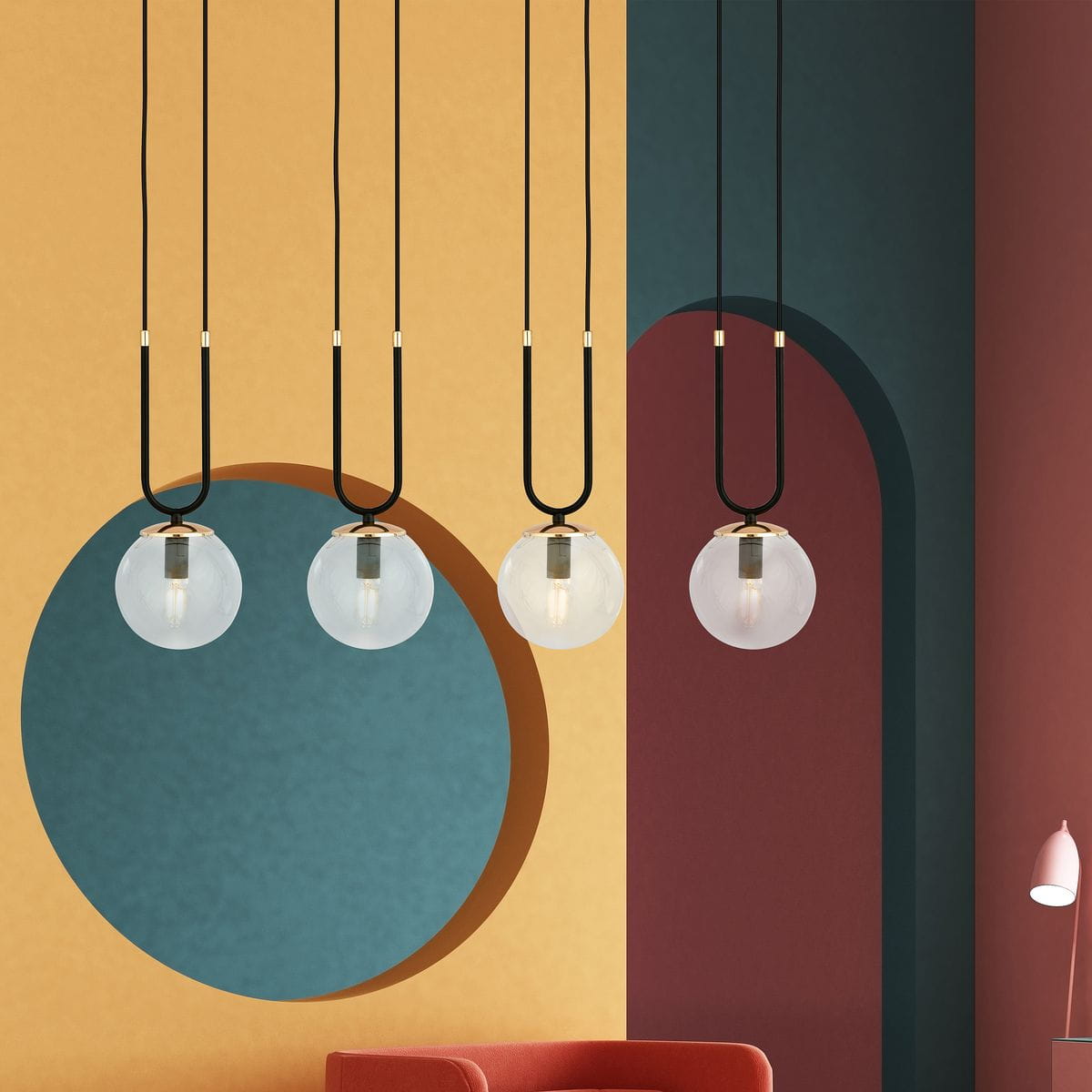 Czarna lampa wisząca Glam 4-punktowa z transparentnymi kulami. Wisi na długich, czarnych przewodach, z metalowymi detalami. W tle kolorowe ściany w odcieniach żółtego, niebieskiego i czerwonego, podkreślające nowoczesny styl aranżacji.