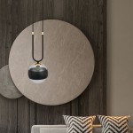 Wisząca lampa Glam 1-punktowa, czarna, z okrągłym kloszem w kolorze przezroczystym i czarnym. Zawieszona na cienkim, czarnym przewodzie, z metalowymi elementami w kolorze złotym. Lampa wisząca w nowoczesnym wnętrzu, na tle okrągłych dekoracji ściennych.