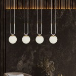 Lampa wisząca 4-punktowa w białym kolorze z okrągłymi kloszami. Klosze zawieszone na cienkich, białych przewodach, z elementami w złotym kolorze. Ujęcie frontalne, w tle ciemna ściana, stylowe wnętrze.