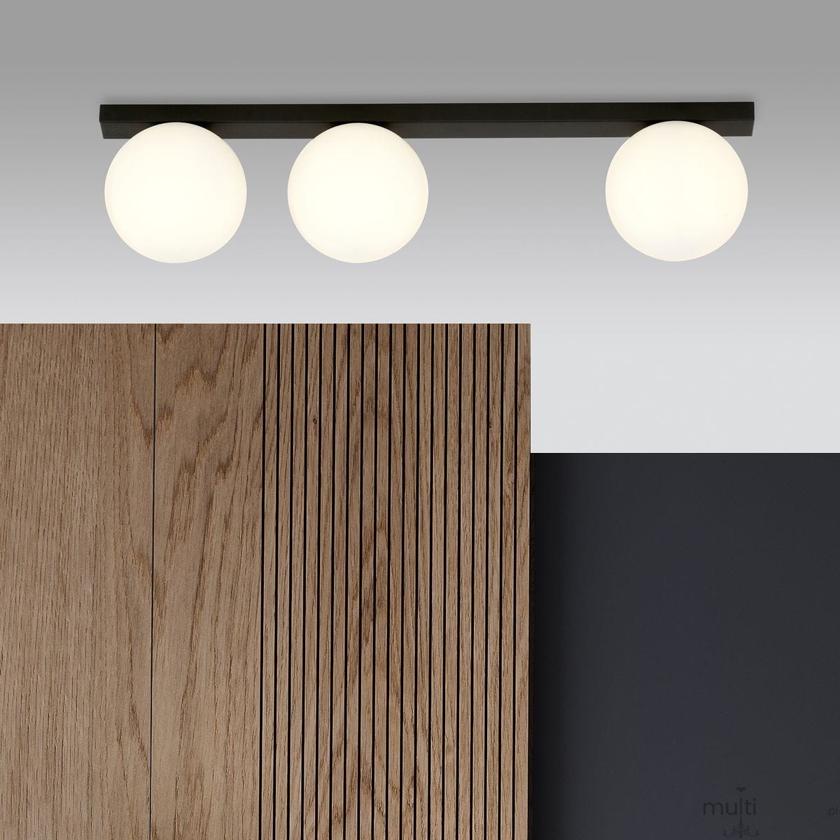 Lampa sufitowa 3-punktowa Fit w kolorze czarnym i białym, zawieszona na prostokątnej, czarnej listwie. Posiada trzy okrągłe klosze w białym kolorze. Widoczna w aranżacji z drewnianym panelem i ciemnym tłem.