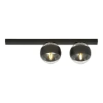 Czarna lampa sufitowa 2-punktowa Fit z metalowym prostokątnym mocowaniem. Dwie okrągłe oprawy z przezroczystym kloszem i czarnym wykończeniem, zamontowane równolegle. Produkt w ujęciu frontalnym, na białym tle.