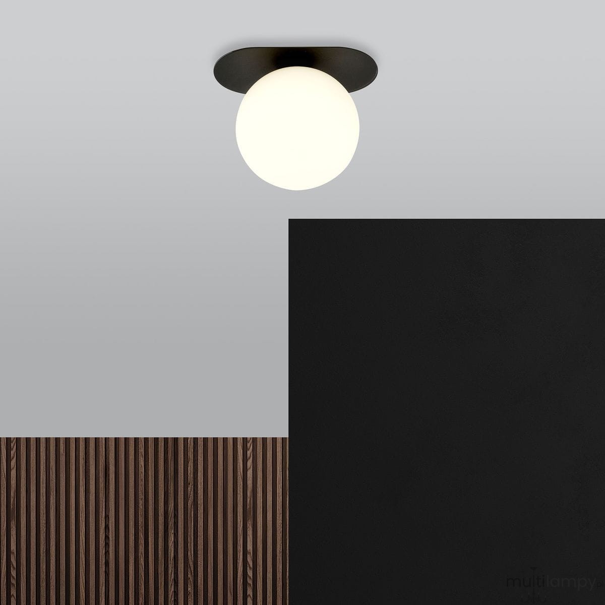 Lampa sufitowa 1-punktowa Plaza w kolorze czarnym i białym, z okrągłą szklaną kloszem. Ujęcie frontalne, montowana na suficie, z tłem w odcieniach szarości oraz czerni. Elementy drewniane widoczne w dolnej części zdjęcia.